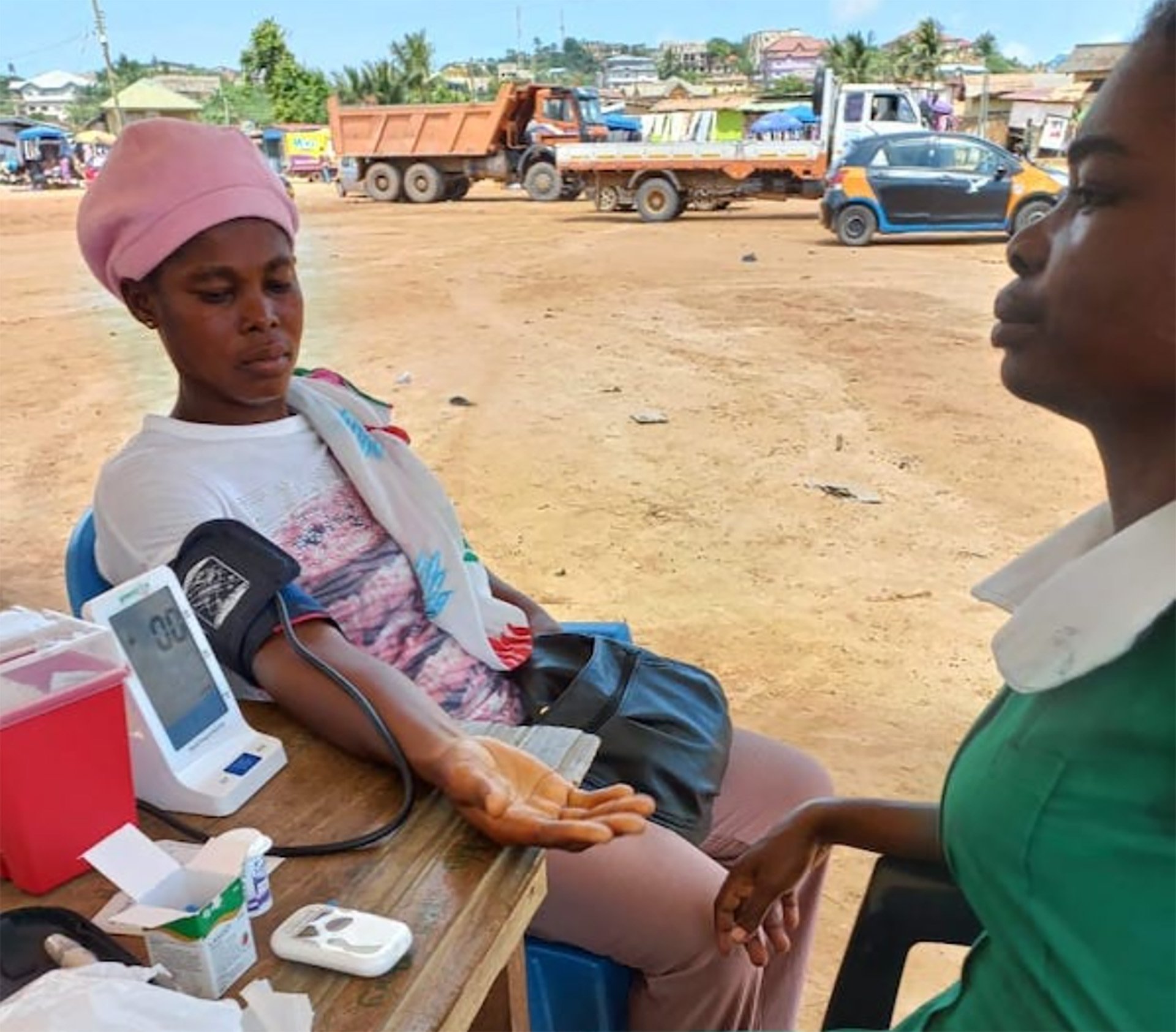 A person sitting at a table with a blood pressure monitor