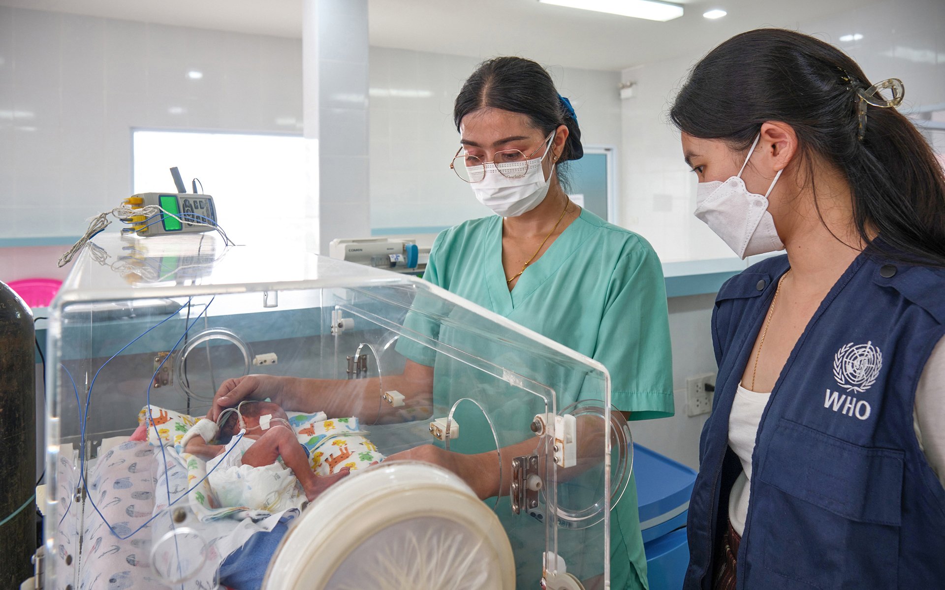 WHO staff and hospital staff checks on the infant in an incubator